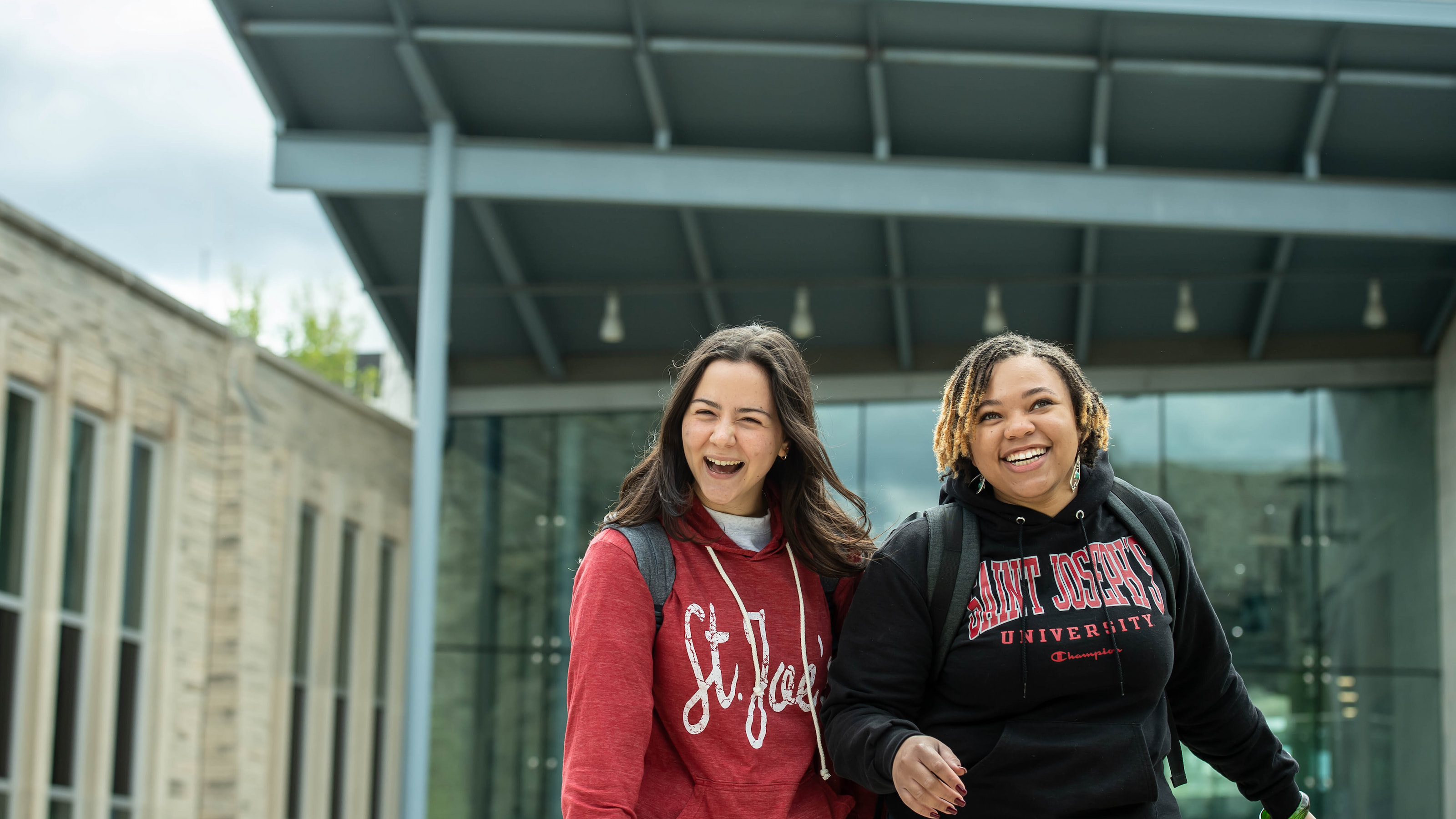 Two Saint Joseph's students laughing outside of the Francis A. Drexel Library