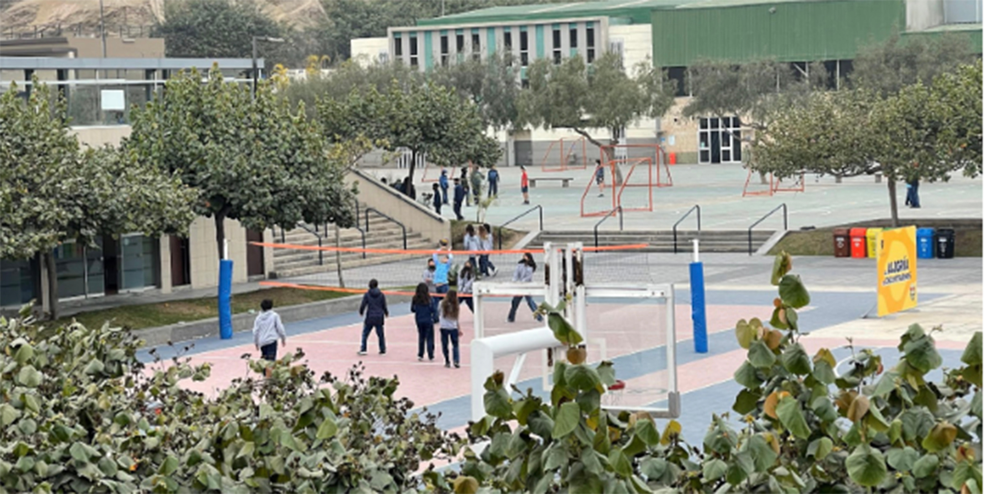 Students playing volleyball in outdoor courtyard
