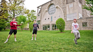Students throwing rugby ball around on Saint Joseph's University campus
