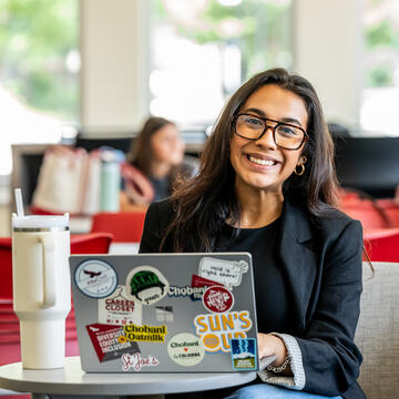 smiling student sitting at laptop