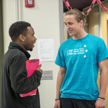 Kinney student and SJU student talk in hallway