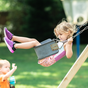 Child on swing set at Camp Kinney