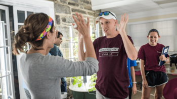 Volunteer and student high five