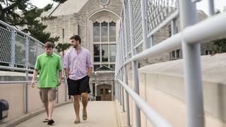 Students walk on bridge from McShain building