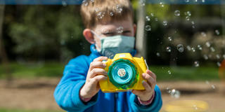 Little boy plays with bubble machine
