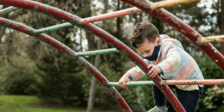 Child with autism plays on jungle gym