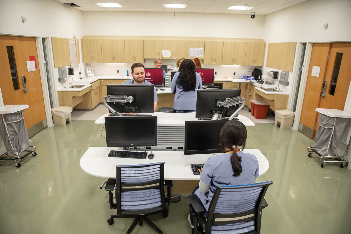 Saint Joseph's University nursing students in a group desk area with computers and chairs