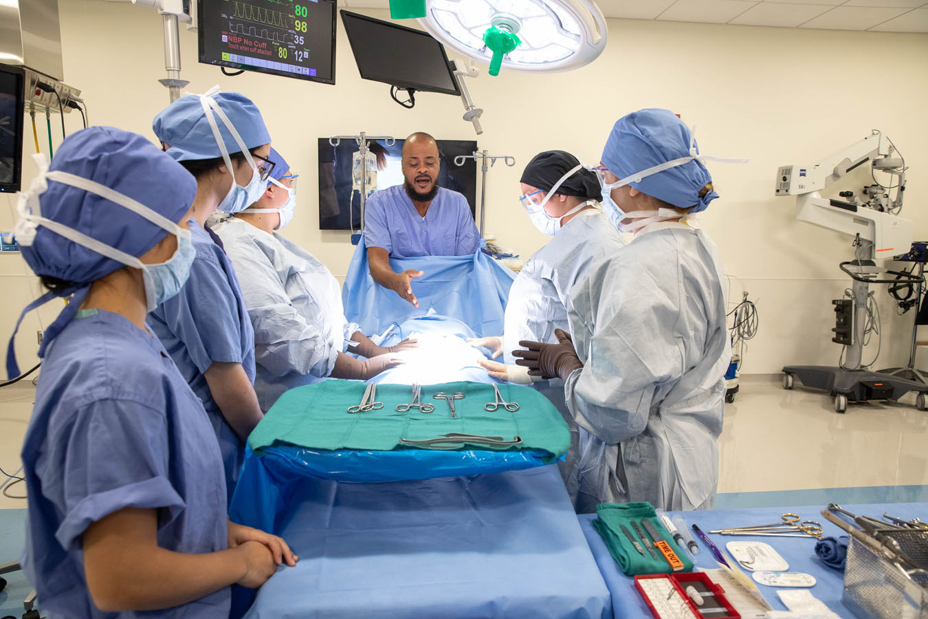 students and doctors in an operating room discussing operating procedures