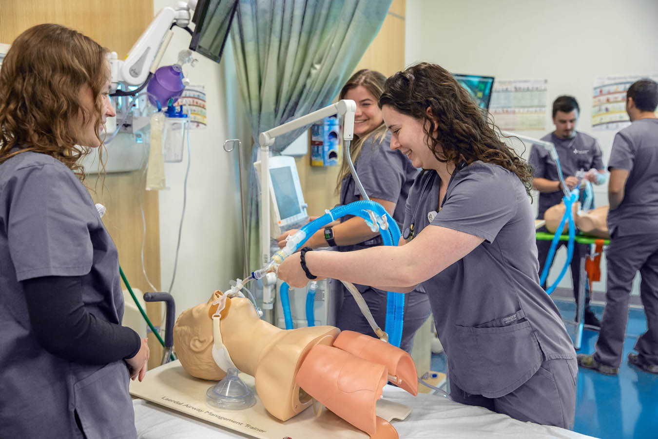 Saint Joseph's University Patient simulator with students practicing on the simulator in classroom setting