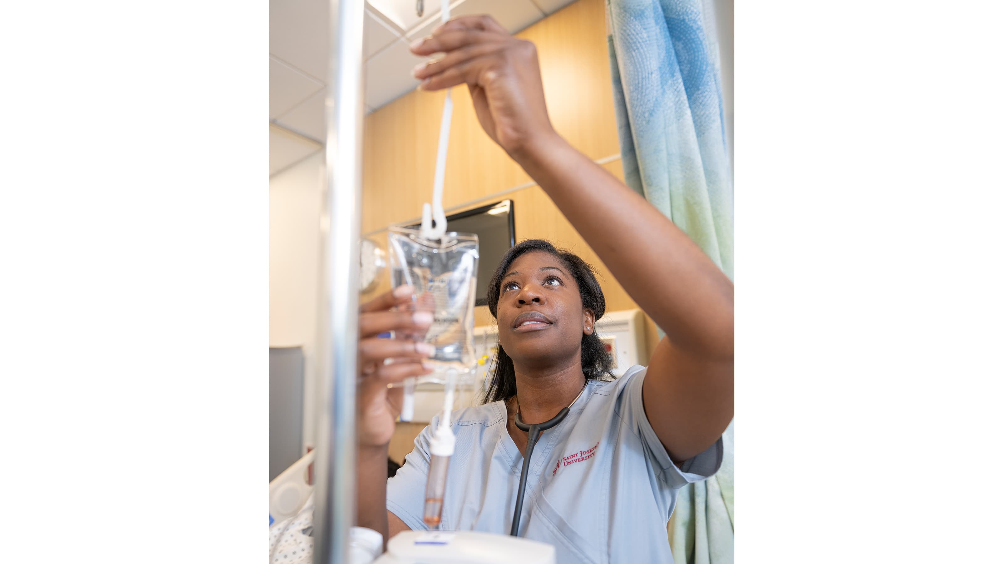Recent photo of female nurse filling up an IV bag