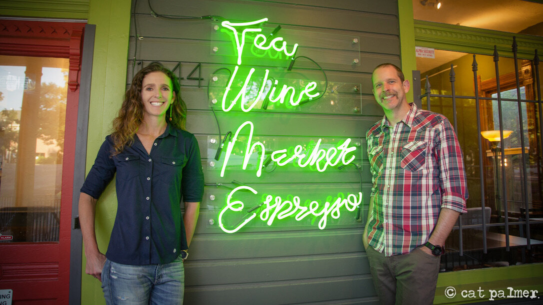 Man and woman standing next to a wall sign