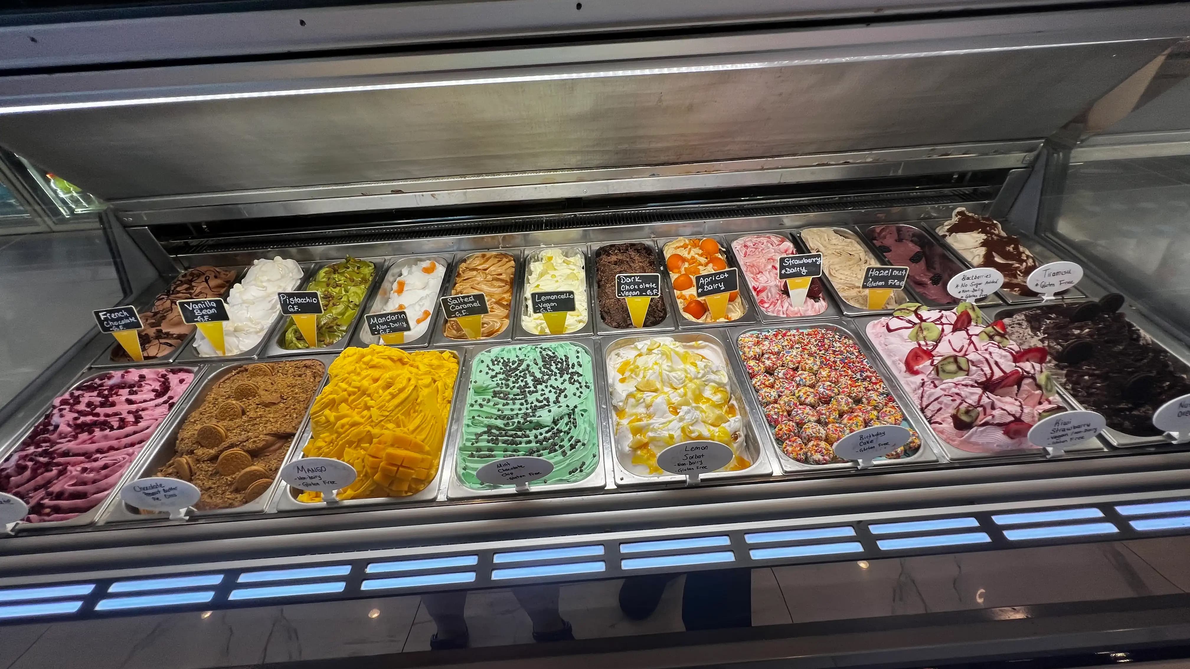 two dozen gelato flavors in display case at ice cream store