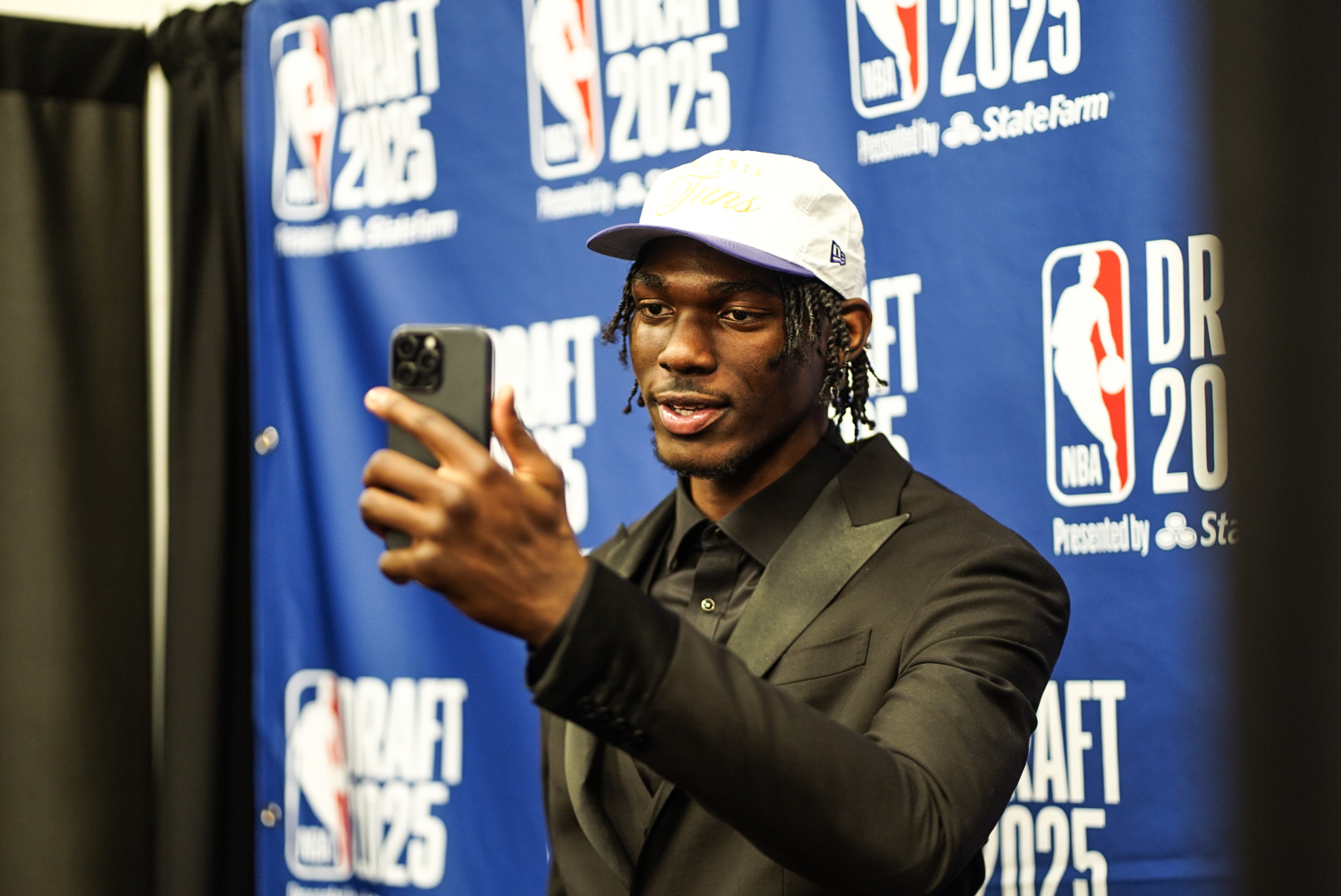 Rasheer Fleming holding up his phone on draft night