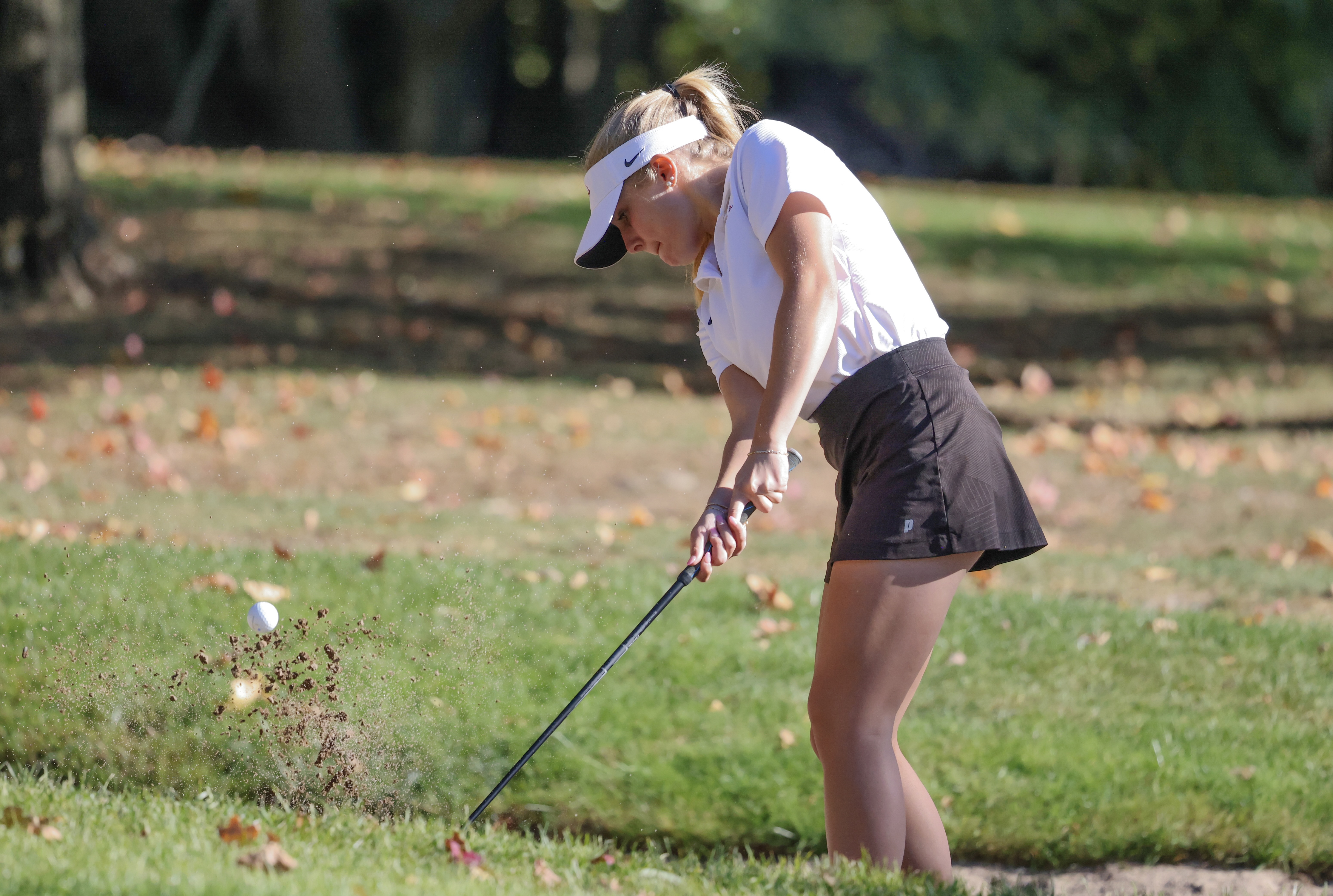 A member of the golf team takes a swing
