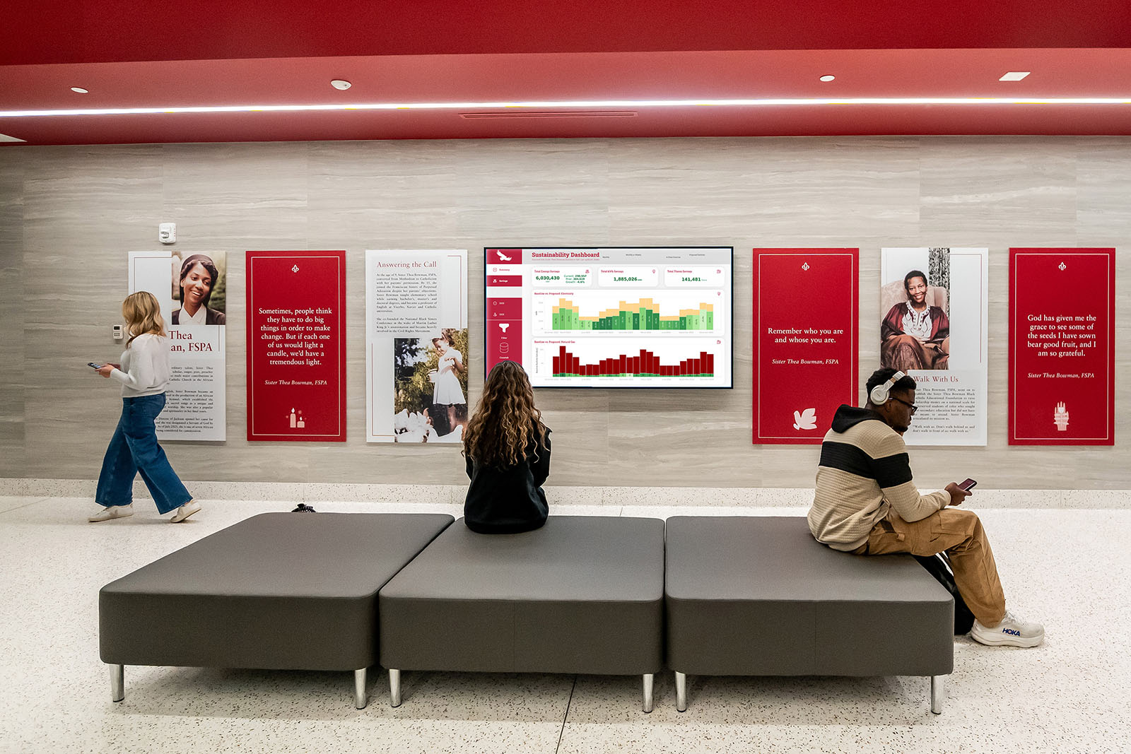 Students sitting on a large bench looking at diagrams on a wall