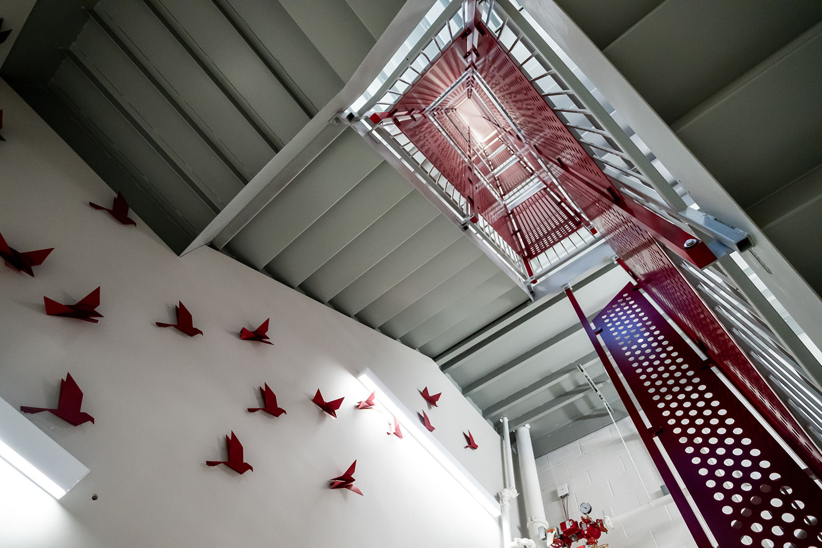 Looking up at a winding red stairwell