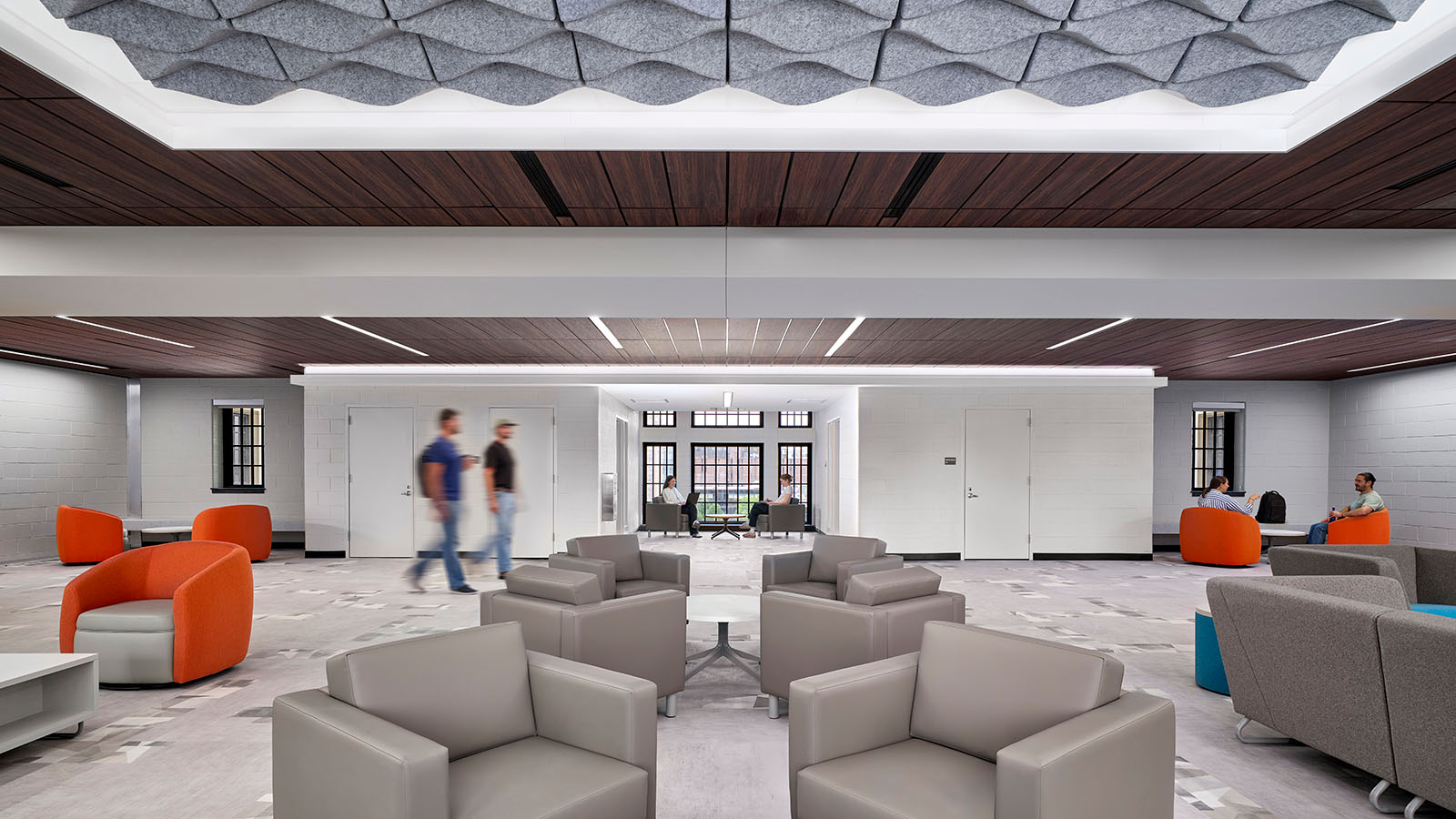 A large room with gray and orange couches