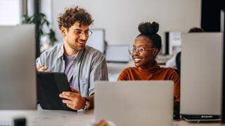 Two young colleagues working together at modern office