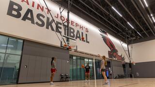 Two female athletes playing on the basketball court in Maguire Athletic Center