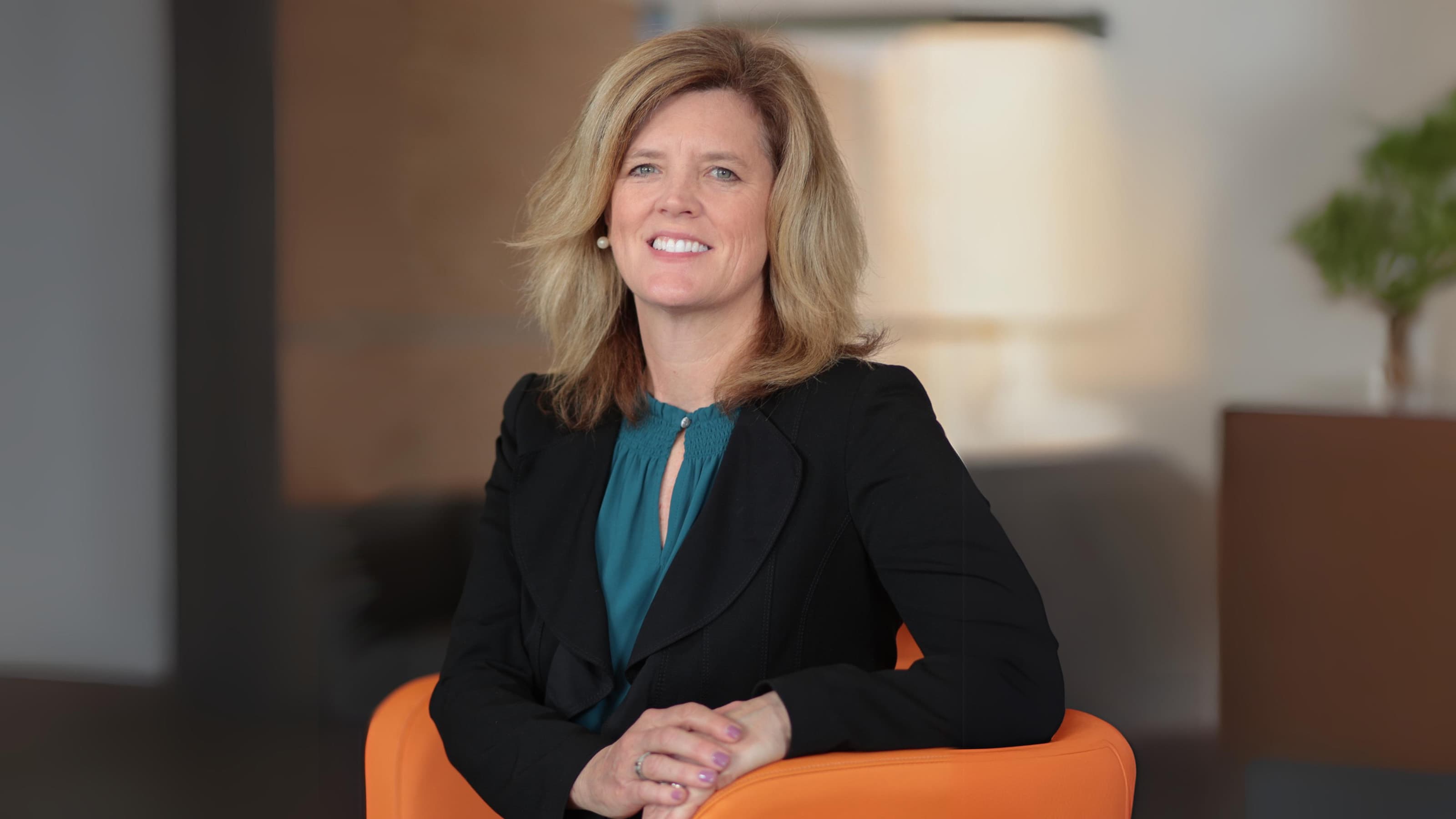 Jean McGivney-Burelle, PhD, seated in an orange chair