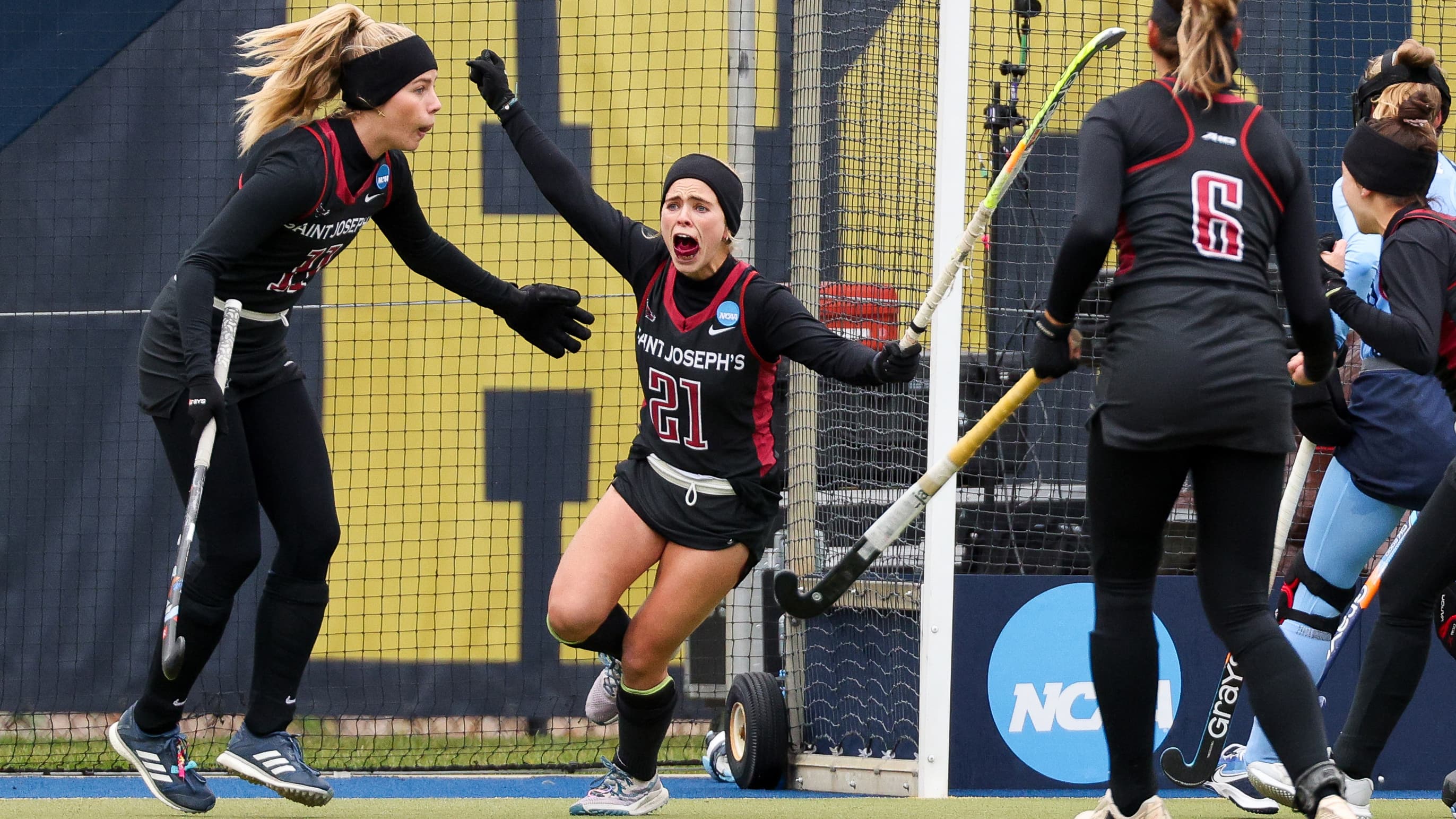 Female field hockey player celebrating winning goal with teammate