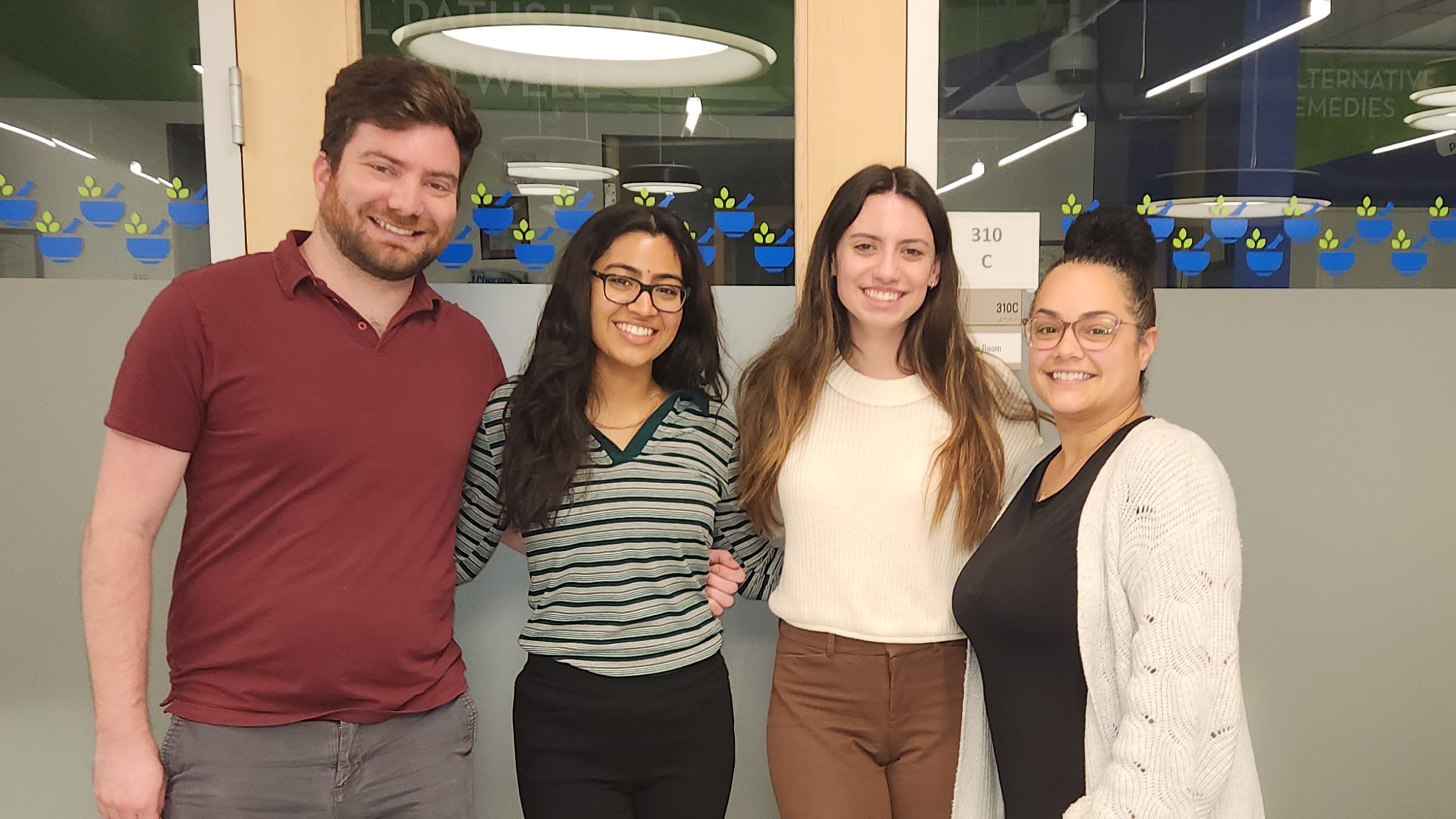 Four students standing in front of a pharmacy