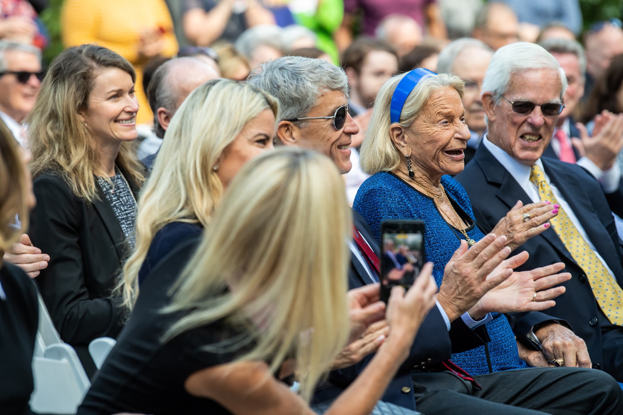 Frances Maguire sitting among crowd of people