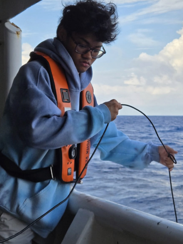 Sean Anjelo Maluchluw wearing life vest on a boat, fishing in the pacific ocean