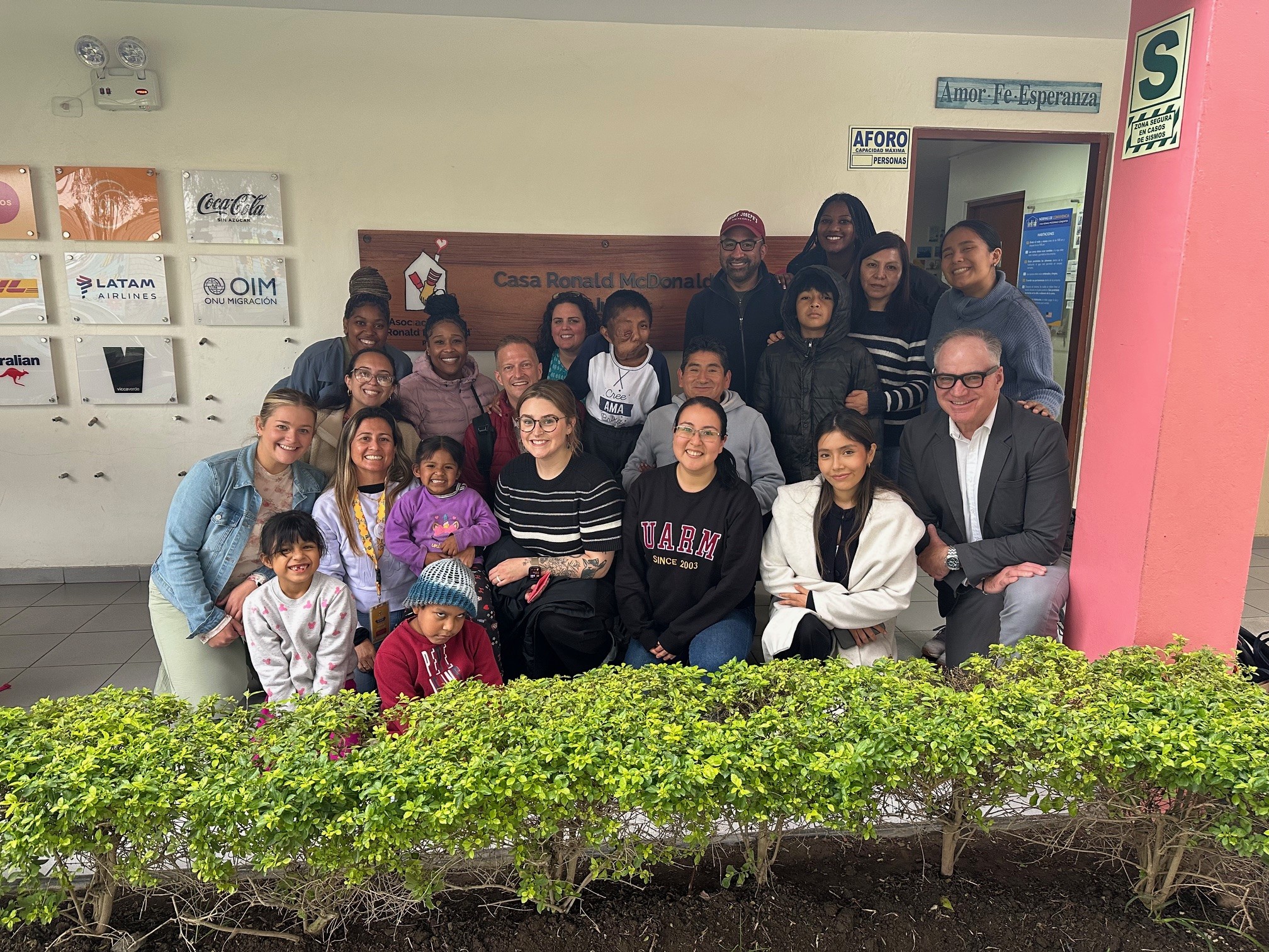 A large group smiles under a pavilion