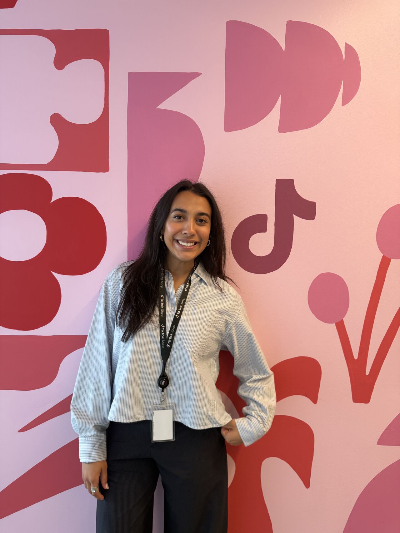 Eshika in front of a pink and red patterned wall