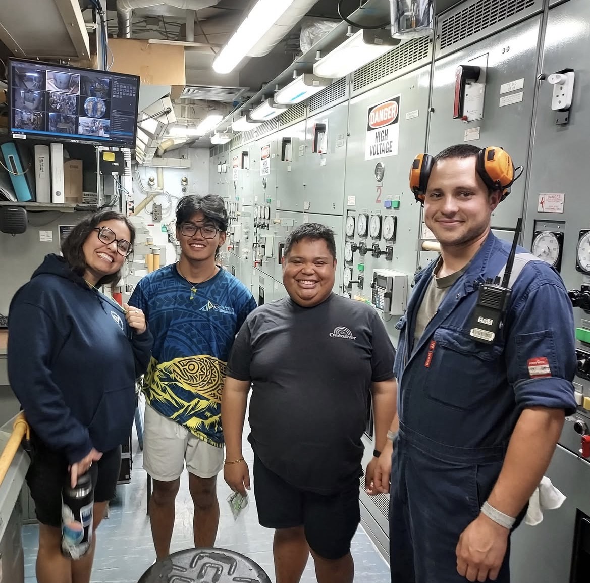 Sean smiling with three other interns in the control room