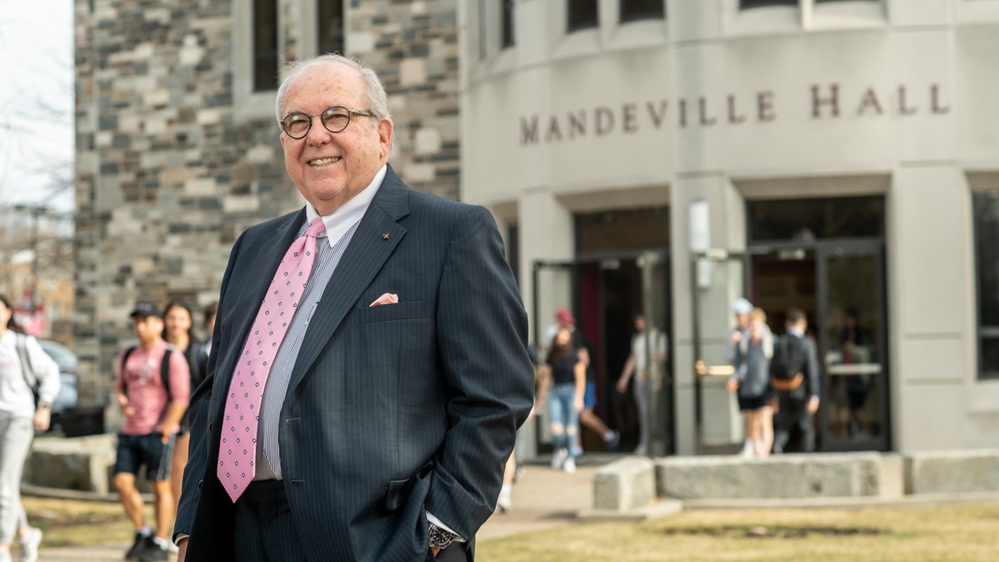 Dean Joseph Diangelo standing in a suit outside of Mandeville Hall