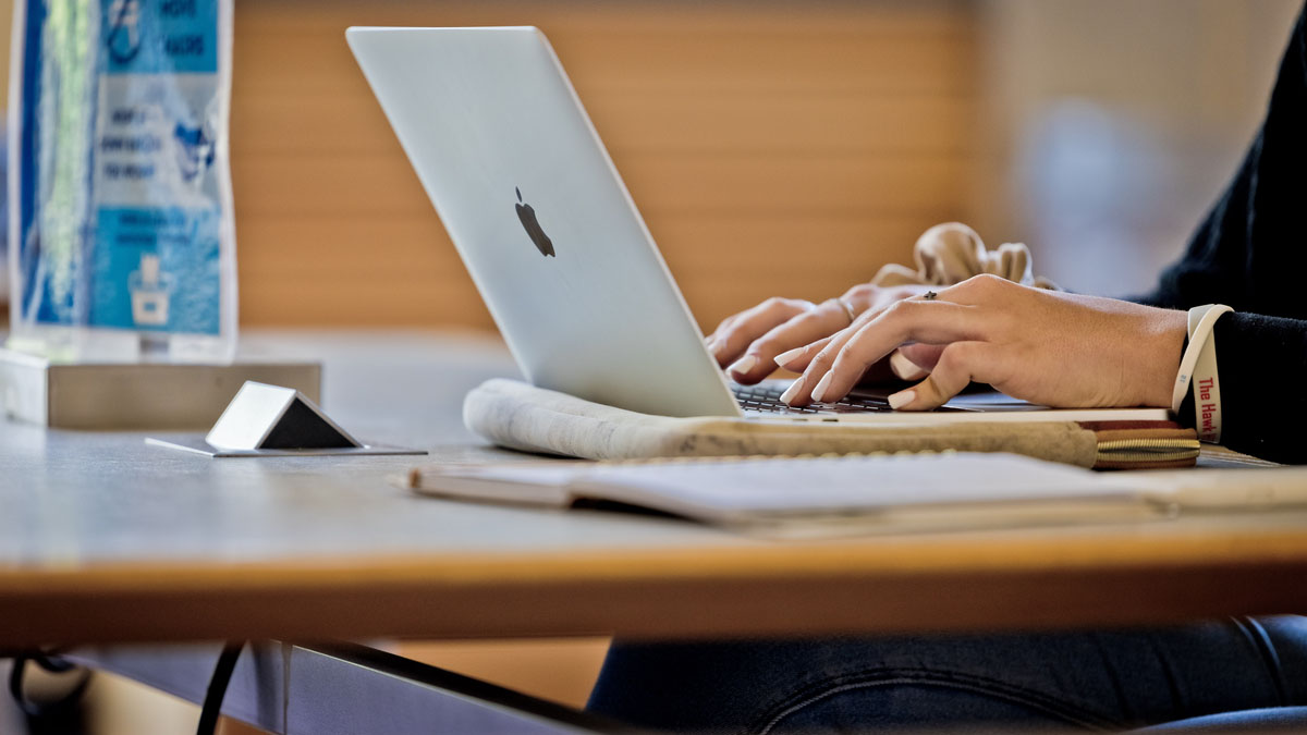 Student typing on laptop