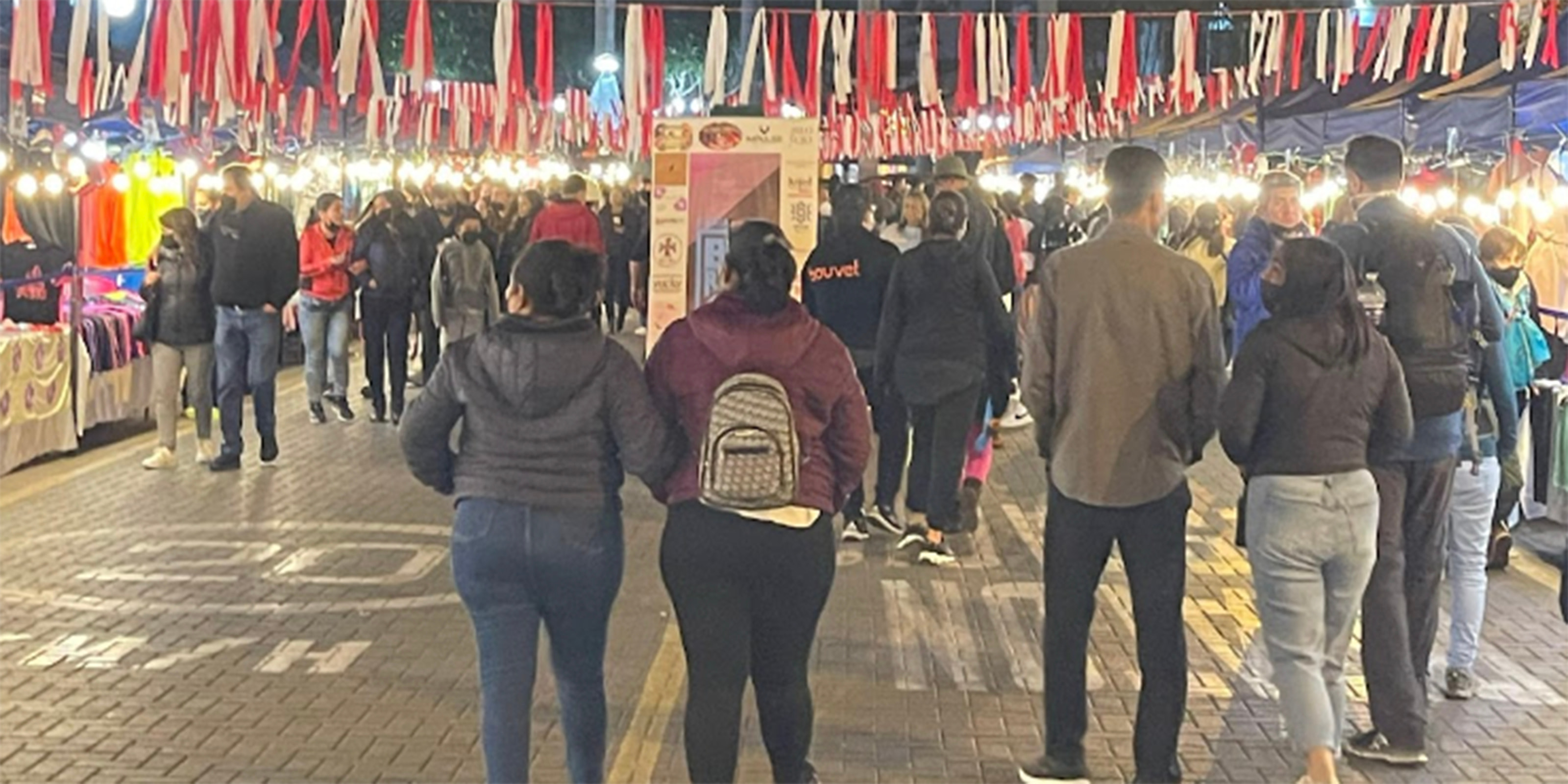 Nighttime market and street festival filled with musicians, food, and shopping. 
