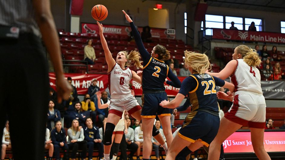 Four players on the basketball court during the SJU-Drexel women's basketball team