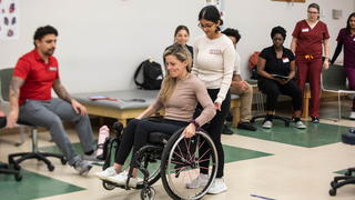 Saint Joseph's University students in classroom setting with a person in a wheelchair
