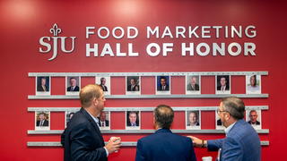 Three gentleman standing in front of Saint Joseph's Food Marketing hall of honor