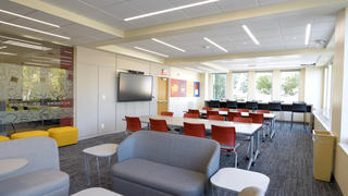 Inside the collaboration center, including lounge chairs, tables and TV's