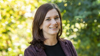 Photo of Theresa McFalls in purple blazer standing outside