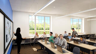 A classroom with rows of tables and students sitting down at them