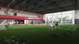 Athletes playing on a green turf field indoors at the new Recreation Center