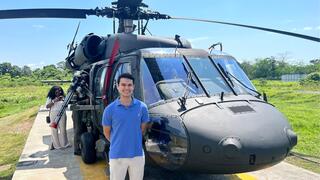 Caleb Datto standing in front of a helicopter