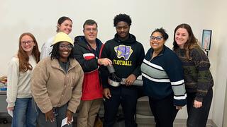 A group of students posed in an OT simulation space