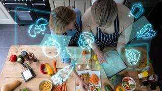 A couple looking at their produce with computer renderings floating above.