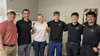 Six students smile at the camera with their arms around each other. 