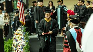 Student walking in front of stage