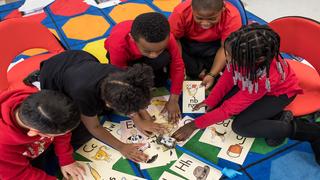 Elementary school students examine flash cards.