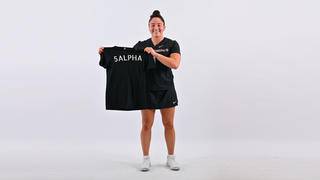 Carina Chieffalo ’25 holds a black 5ALPHA shirt in front of her