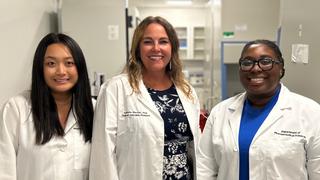 Caitlyn Ulmer ’24, Isabelle Mercier and Jenifer Nguyen in white lab coats