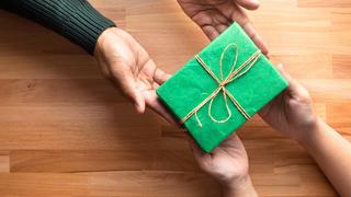 Adult gives a gift present to child.